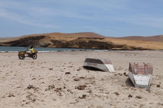 A guy scoots by some overturned fishing boats in La Reserva Nacional De Paracas. Photo: Alex Washburn