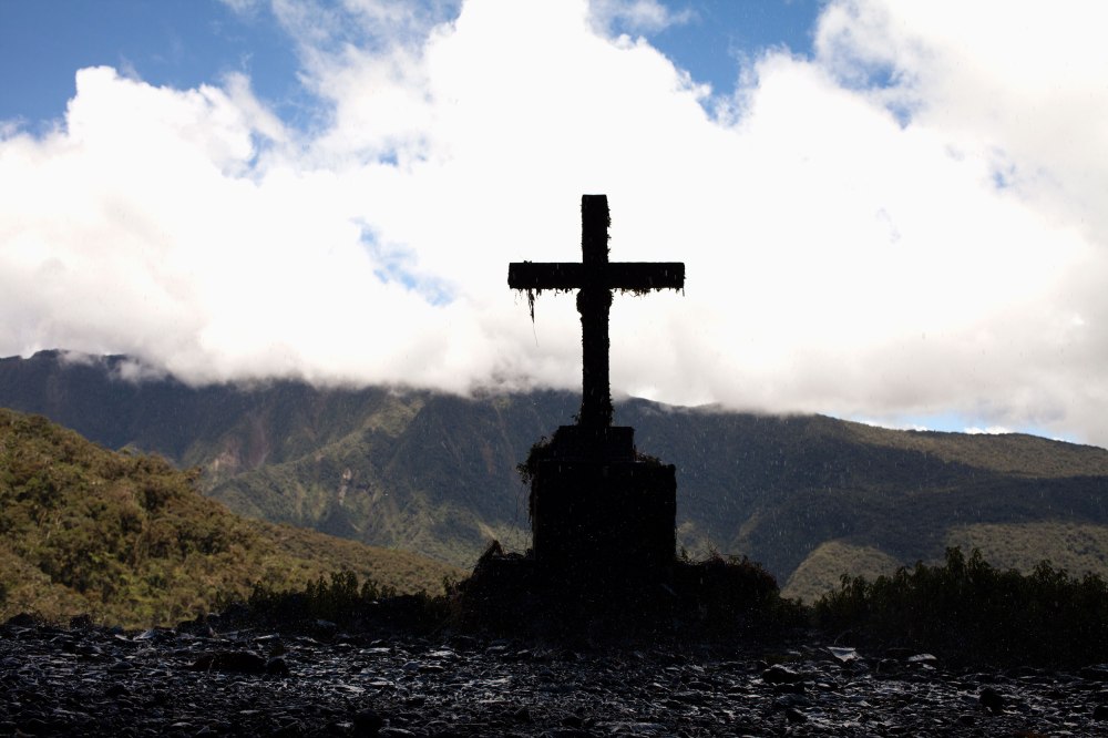 A cross marks where people have died on the Bolivian Death Road near a series of small waterfalls. Photo: Alex Washburn